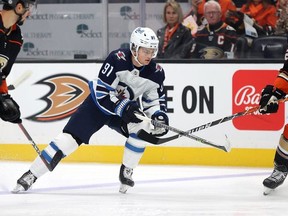 Cole Perfetti #91 of the Winnipeg Jets skates the puck against Kevin Shattenkirk #22 of the Anaheim Ducks in the first period at Honda Center on October 13,