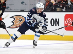 Cole Perfetti #91 of the Winnipeg Jets skates the puck against Kevin Shattenkirk #22 of the Anaheim Ducks in the first period at Honda Center on October 13,