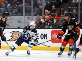 ANAHEIM, CALIFORNIA - OCTOBER 13:  Cole Perfetti #91 of the Winnipeg Jets skates the puck against Kevin Shattenkirk #22 of the Anaheim Ducks in the first period at Honda Center on October 13, 2021 in Anaheim, California.