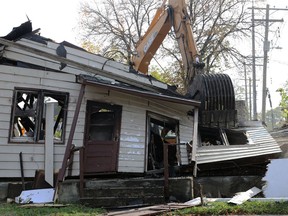 A man working an excavator demolishes a vacant house destroyed by fire in the 200 block of Salter Street in Winnipeg on Sunday, Oct. 3, 2021.