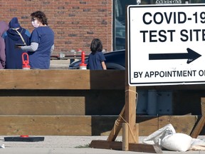An employee collects information at a COVID-19 mobile testing site on Portage Avenue in Winnipeg on Monday, Oct. 4, 2021.