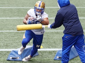Brady Oliveira (left) is bothered by Andrew Harris while carrying the ball during Winnipeg Blue Bombers practice on Tuesday, Oct. 19, 2021.