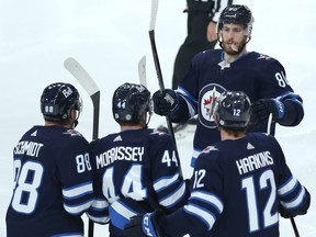 Winnipeg Jets centre Pierre-Luc Dubois (top right) celebrates a goal against the Anaheim Ducks from Josh Morrissey (middle bottom) along with Nate Schmidt (left) and Jansen Harkins in Winnipeg on Thursday, Oct. 21, 2021.