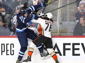 Winnipeg Jets defenceman Logan Stanley (left) stands up Anaheim Ducks defenceman Josh Mahura with a bodycheck in Winnipeg on Thursday, Oct. 21, 2021.