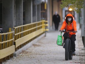 A person wears a mask while cycling in public in Winnipeg on Friday, Oct. 29, 2021.