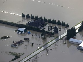 In an aerial view, floodwaters surround homes and farms on November 20, 2021 in Abbotsford, British Columbia. The Canadian province of British Columbia declared a state of emergency on Wednesday following record rainfall earlier this week that has resulted in widespread flooding of farms, landslides and the evacuation of residents. (Photo by Justin Sullivan/Getty Images)
