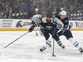 Winnipeg Jets centre Jansen Harkins (12) skates around Columbus Blue Jackets right wing Jakub Voracek (93) during the first period at Nationwide Arena.