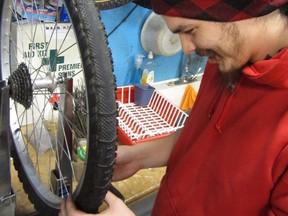 Fred De Dederick, a team member with Macdonald Youth Service’s (MYS) social enterprise Mayfair Innovations, works on a bike repair in Winnipeg. MYS has now launched Velotecha, a new valet and bike repair service for Winnipeg cyclists that will work to provide opportunities and work experience to local youth. Photo by Allan Sileski.