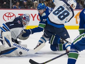 Nov 19, 2021; Vancouver, British Columbia, CAN; Winnipeg Jets goalie Eric Comrie (1) makes a save on Vancouver Canucks forward Tanner Pearson (70) as Winnipeg Jets defenseman Nate Schmidt (88) checks Pearson in the first period at Rogers Arena. Mandatory Credit: Bob Frid-USA TODAY Sports