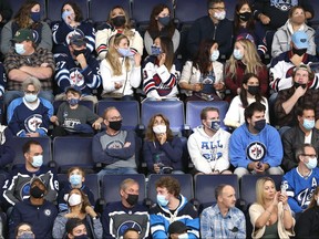 Masked fans at Canada Life Centre in Winnipeg for an NHL exhibition match between the Jets and Ottawa Senators on Sunday, Sept. 26, 2021.