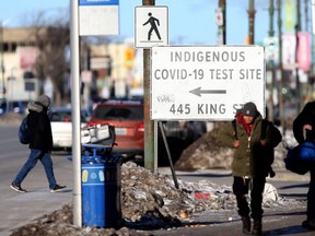 People walk past a sign for a Covid-19 test site in Winnipeg.  Chris Procaylo,  Wednesday Nov. 24. 2021 Winnipeg Sun