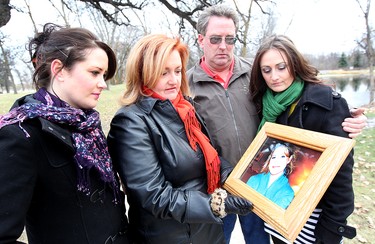 Scott and Lori McFarland with their daughters Ashley (left) and Lisa look at a photo of Amber McFarland in Portage La Prairie, Manitoba Saturday October 27, 2012. Amber has been missing since October 2008.