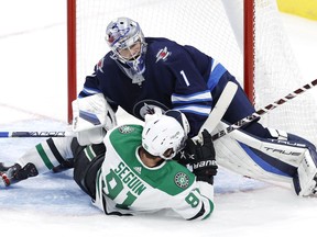 Dallas Stars center Tyler Seguin (91) collides with Winnipeg Jets goaltender Eric Comrie (1) in the third period at Canada Life Centre in Winnipeg on Nov. 2, 2021.