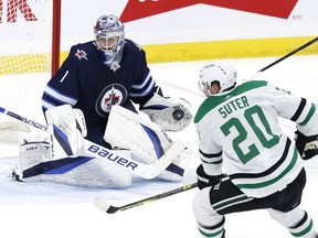 Winnipeg Jets goaltender Eric Comrie (1) blocks a shot from Dallas Stars defenceman Ryan Suter (20) in overtime at Canada Life Centre in Winnipeg on Nov. 2, 2021.