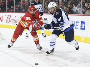 Winnipeg Jets forward Kyle Connor (81) battles for the puck with Calgary Flames forward Elias Lindholm (28) during the second period at Scotiabank Saddledome in Calgary on Nov. 27, 2021. Connor had two goals including the game-winner in a 4-2 Jets victory to snap a five-game losing streak.