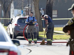 Firefighters clean up the intersection of Burrows Avenue and Aikins Street in Winnipeg on Sunday, Nov. 7, 2021. The Homicide Unit is investigating after police responding to an assault call found an unresponsive man who was transported to hospital where he was pronounced dead.