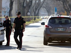 Police officers near a homicide scene at the intersection of Burrows Avenue and Aikins Street in Winnipeg on Sunday, Nov. 7, 2021. The Homicide Unit is investigating after police responding to an assault call found an unresponsive man who was transported to hospital where he was pronounced dead.