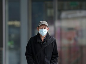 A man wearing a mask walks in True North Square in downtown Winnipeg on Monday, Nov. 1, 2021.