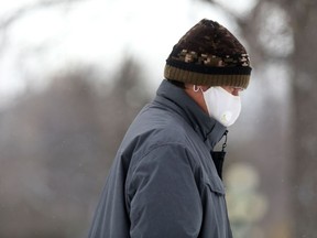 A person wears a mask while walking in Winnipeg on Friday Nov. 12, 2021.