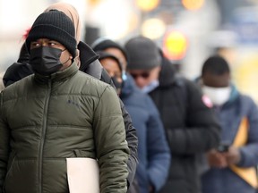 People lined up outside a Main Street office building in Winnipeg on Monday, Nov. 15, 2021.