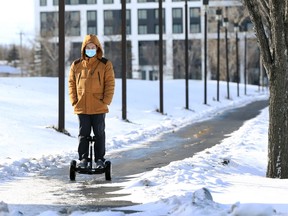 A man wearing a mask rides an electric scooter along Chancellor Matheson Boulevard in Winnipeg on Thurs., Nov. 18, 2021.  KEVIN KING/Winnipeg Sun/Postmedia Network