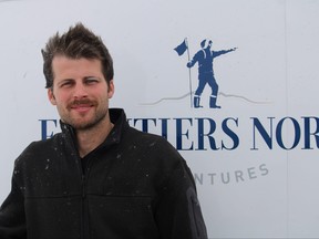 Frontiers North Adventures head mechanic Tye Noble poses for a photo outside Churchill Man., while Tundra Buggy passengers observe polar bears on Nov. 20, 2021.