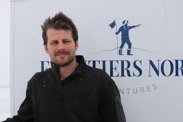 Frontiers North Adventures head mechanic Tye Noble poses for a photo outside Churchill Man., while Tundra Buggy passengers observe polar bears on Nov. 20, 2021.