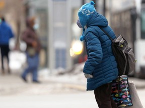 A woman wearing a mask walks in downtown Winnipeg on Monday, Nov. 22, 2021.