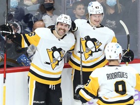 Pittsburgh Penguins forward Jason Zucker (left) celebrates his second-period goal against the Jets in Winnipeg with Danton Heinen (centre) and Evan Rodrigues on Monday, Nov. 22, 2021.