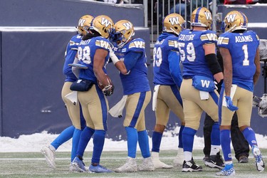 Winnipeg Blue Bombers RB Andrew Harris (right) congratulates receiver Rasheed Bailey on his touchdown catch against the Saskatchewan Roughriders in the CFL West Final in Winnipeg on Dec. 5, 2021.