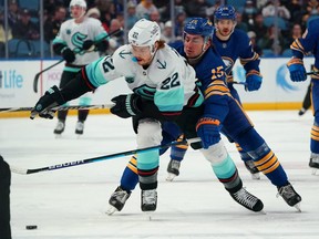 Mason Appleton #22 of the Seattle Kraken and John Hayden #15 of the Buffalo Sabres fight for position during the first period at KeyBank Center on November 29, 2021 in Buffalo, New York. (Photo by Kevin Hoffman/Getty Images)