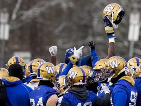Winnipeg Blue Bombers defensive lineman Willie Jefferson holds his helmet up in a team huddle during practice at McMaster University this week. THE CANADIAN PRESS