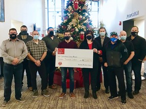 Christmas Cheer Board Executive Director Shawna Bell (right, holding cheque) accepts a donation of $13,000 from the Manitoba Building Trades at their office in Winnipeg on Dec. 1.