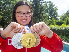 Maggie Mac Neil shows off her set of gold, silver, and bronze medals she won in Tokyo.