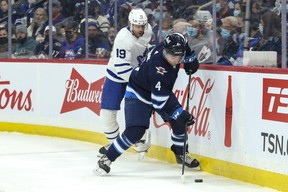 Winnipeg Jets' Neal Pionk skates away from Maple Leafs' Jason Spezza during the first period at Canada Life Centre on Sunday, Dec. 5, 2021.