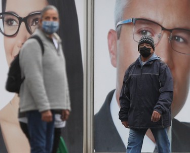Two people wear masks while walking in public in Winnipeg on October 15. Chris Procaylo/Winnipeg Sun