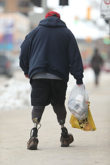 A person walks along a downtown street on two prosthetic legs, in Winnipeg on Nov. 19. Chris Procaylo/Winnipeg Sun
