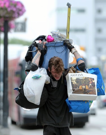 A man struggles with the weight of belongings while on the move in the Osborne Village area of Winnipeg on Mon., July 26, 2021. KEVIN KING/Winnipeg Sun/Postmedia Network