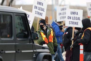 A picket captain stops traffic on University Crescent in Winnipeg after the University of Manitoba Faculty Association went on strike on Tues., Nov. 2, 2021. Vehicles were briefly stopped until information pamphlets could be distributed.  KEVIN KING/Winnipeg Sun/Postmedia Network
