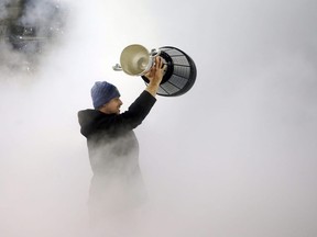 Quarterback Zach Collaros emerges from the fog with the Grey Cup as the Winnipeg Blue Bombers celebrated its championship victory at IG Field on Wed., Dec. 15, 2021.  KEVIN KING/Winnipeg Sun/Postmedia Network