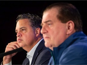 Travis Green, back left, and Jim Benning have reportedly been fired on Sunday.