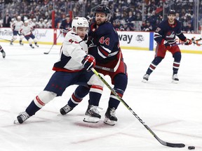 Washington Capitals left wing Conor Sheary (73) and Winnipeg Jets defenceman Josh Morrissey (44) collide in the first period at Canada Life Centre at Canada Life Centre in Winnipeg on Dec. 17, 2021.