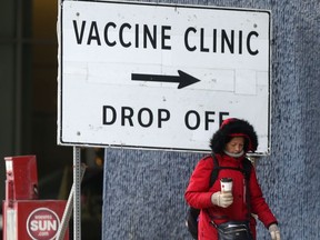 A person walks past a vaccine clinic sign in Winnipeg during the Covid-19 pandemic.  Chris Procaylo,  Tuesday Nov. 30. 2021 Winnipeg Sun