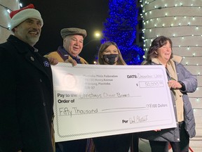 (Left to right) Manitoba Métis Federation Housing Minister Will Goodon, Manitoba Métis Federation President David Chartrand, Chartrand's granddaughter Martha Chartrand, and Christmas Cheer Board Executive Director Shawna Bell stand with over-sized cheque for the MMF's $50,000 donation to the Christmas Cheer Board in front of the the new Métis Nation Heritage Centre at Portage and Main in Winnipeg on Friday, Dec. 3, 2021. It marks the second year that the MMF - a long-time supporter of the Christmas Cheer Board - has donated $50,000.