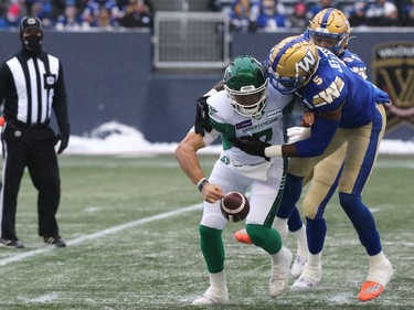 Winnipeg Blue Bombers DE Willie Jefferson (right) forces a fumble from Saskatchewan Roughriders QB Cody Fajardo in the CFL West Final in Winnipeg on Sunday, Dec. 5, 2021.