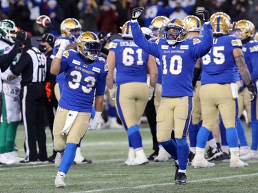 Winnipeg Blue Bombers RB Andrew Harris (left) and slotback Nic Demski celebrate in the dying seconds of their win over the Saskatchewan Roughriders in the CFL West Final in Winnipeg on Sunday, Dec. 5, 2021.