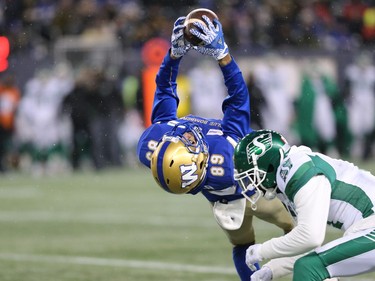 Winnipeg Blue Bombers WR Kenny Lawler makes a tough catch in front of Saskatchewan Roughriders DB Ed Gainey in the CFL West Final in Winnipeg on Sunday, Dec. 5, 2021.