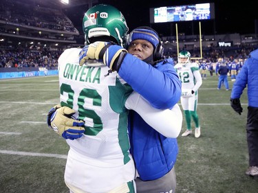 Winnipeg Blue Bombers defensive backs coach Jordan Younger (right) hugs Saskatchewan Roughriders DB Godrey Onyeka after the CFL West Final in Winnipeg on Sunday, Dec. 5, 2021.