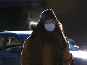 A woman wearing a mask with fogged glasses walks in Osborne Village in Winnipeg on Monday, Dec. 6, 2021.