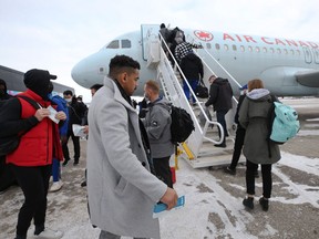 Andrew Harris and the rest of the Winnipeg Blue Bombers board a plane at Winnipeg International Airport on Tuesday, Dec. 7, 2021, en route to the 108th Grey Cup against the Tiger-Cats in Hamilton on Sunday.